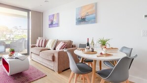 Un salon moderne comprenant un canapé, une table à manger, des chaises et des œuvres d’art accrochées aux murs.