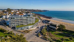 Un hôtel situé sur la côte, avec plusieurs étages, un parking et une vue sur la plage.