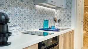 A modern kitchen with patterned backsplash, a coffee maker, and a toaster.