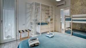 A bedroom with bunk beds, a wardrobe, and a bedside table.