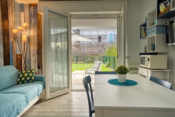 Une cuisine moderne avec un coin repas, un canapé et une vue sur le jardin arrière.