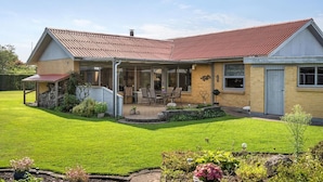 A two-story house with a covered patio, a brick exterior, and a red roof. - Lækkert hus tæt på alt (Billund)