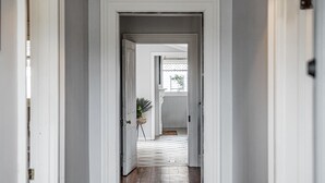 Un pasillo con suelo de madera y paredes blancas.
