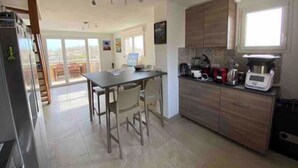Una cocina moderna con comedor, ventanas amplias y vistas al exterior.