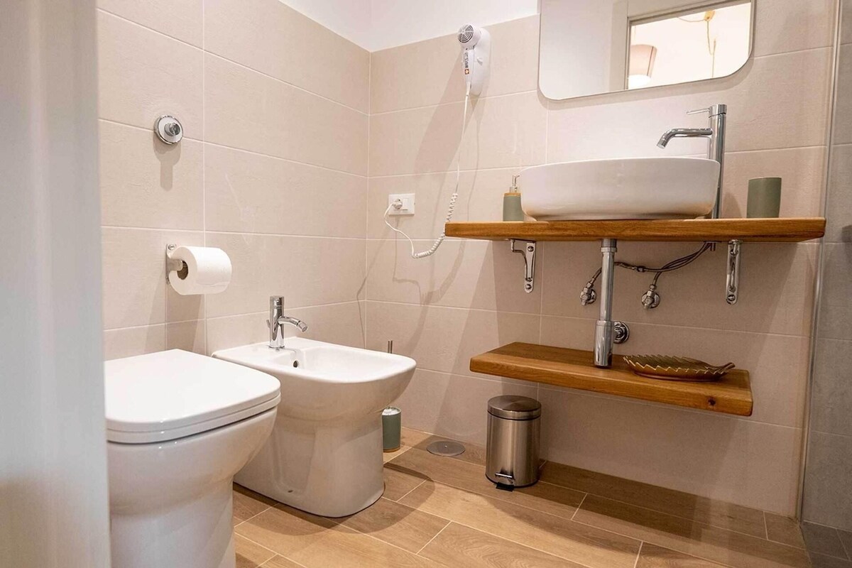 Un baño moderno con inodoro, bidé, lavabo y ducha.