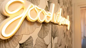 A wall with a neon sign spelling "Good vibes" in cursive letters. - Smart Guesthouse (Rome)