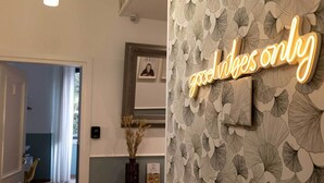 A hallway with a neon sign reading "and likes only" and a patterned wallpaper. - Smart Guesthouse (Rome)