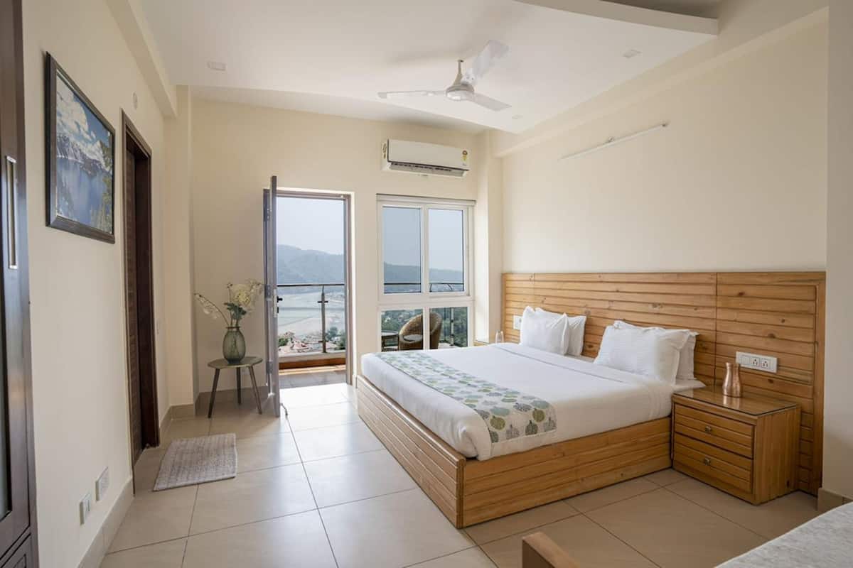 A bedroom with a wooden bed, a nightstand, a bedside table, a window with a view, and a ceiling fan.