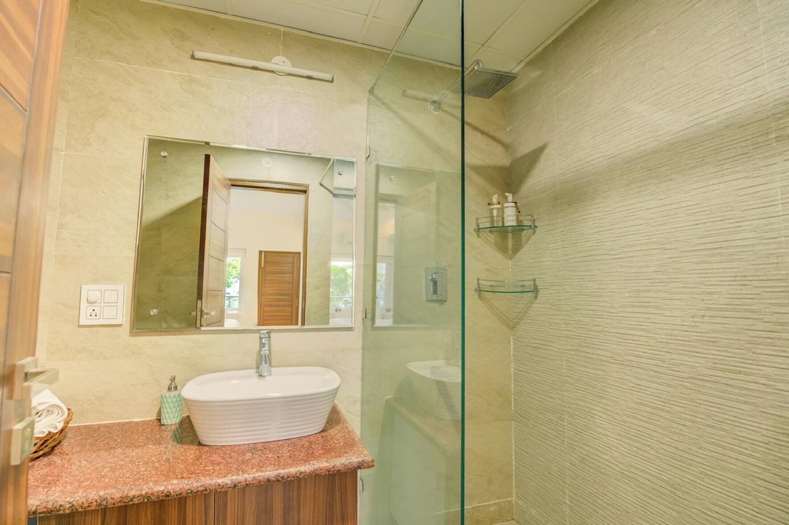A modern bathroom with a freestanding sink, a glass shower enclosure, and a mirror above the sink.