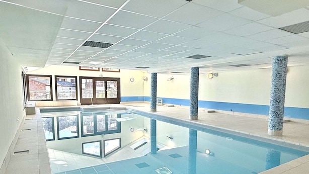 A swimming pool with clear water, tiled walls, and a tiled floor.