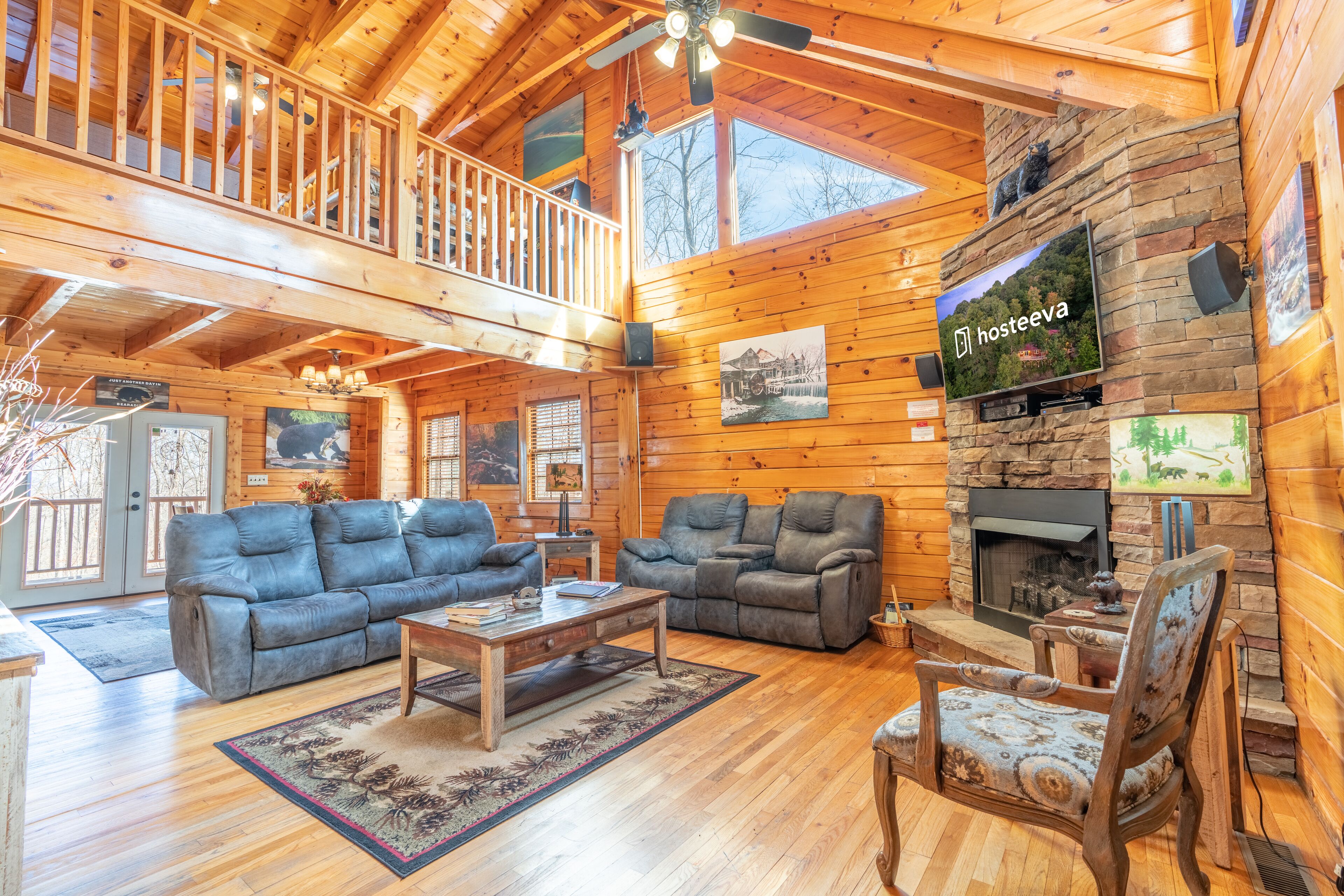 Une cabane en bois spacieuse, avec un salon comprenant deux canapés, une table basse et une cheminée.