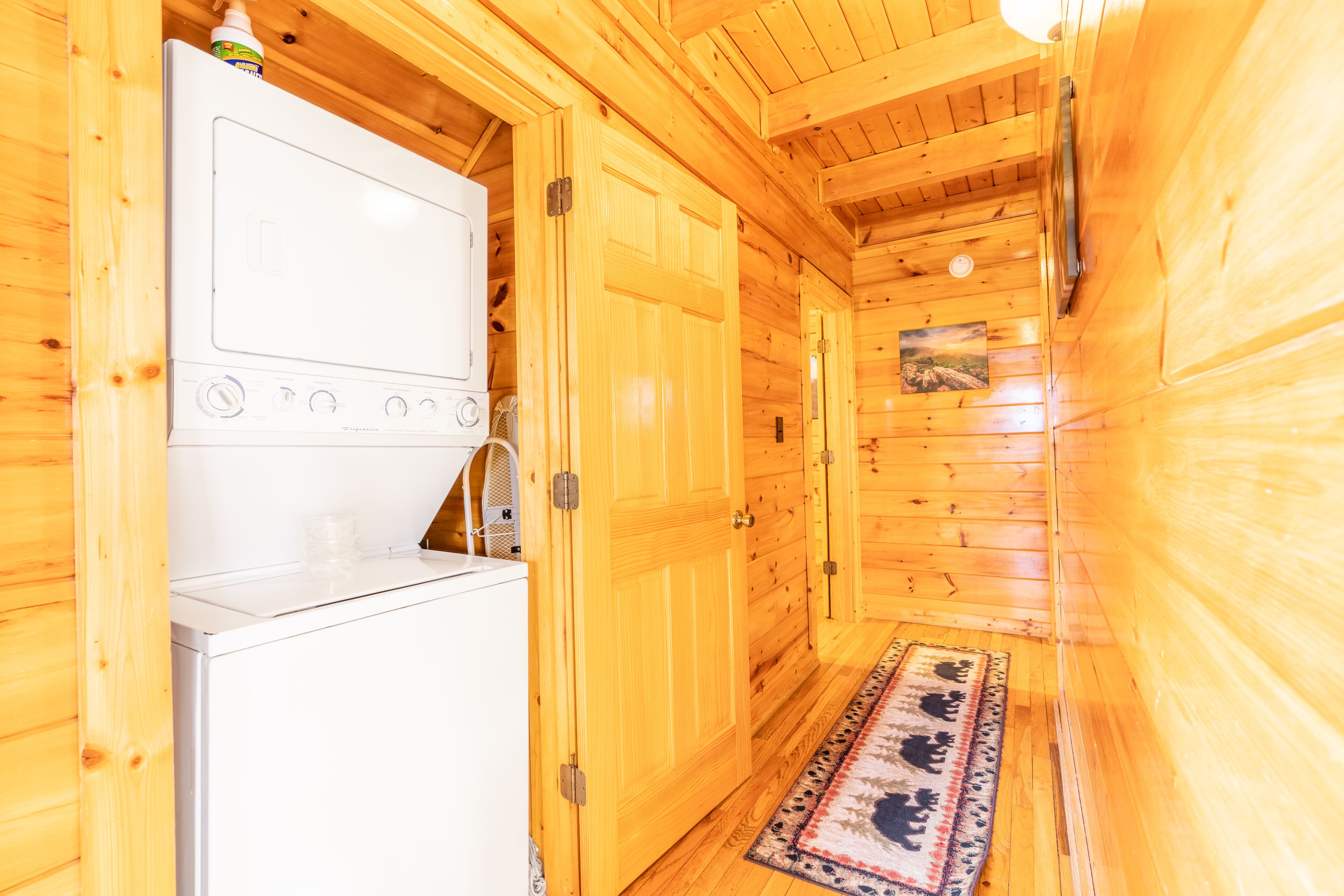 A compact wooden cabin with a kitchenette, including a stove and a refrigerator.