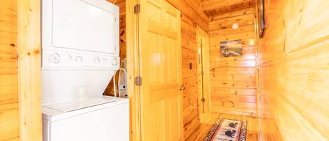 A compact wooden cabin with a kitchenette, including a stove and a refrigerator.