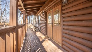 A wooden log cabin with a covered porch, wooden doors, and a lantern. - Comfort Cabin Bearway To Heaven - w Private Hot Tub (Pigeon Forge)