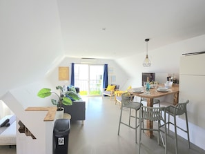 A modern apartment with a dining area, kitchen, and living space.