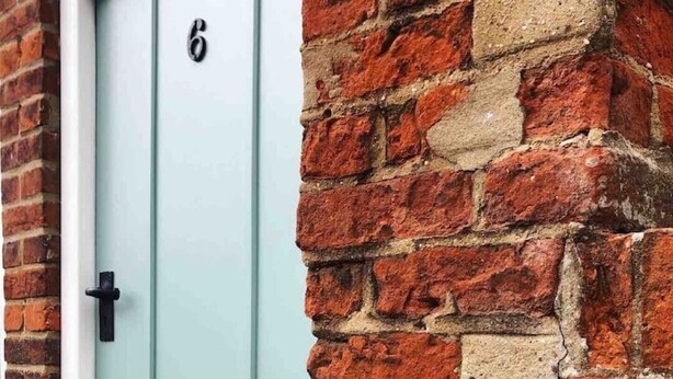 A light blue door with the number 6 and a plaque reading "Georgian Cottage". - Charming Georgian flint cottage (BURY ST. EDMUNDS)