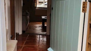 A hallway with a doormat that reads "Welcome" and a light blue door. - Charming Georgian flint cottage (BURY ST. EDMUNDS)