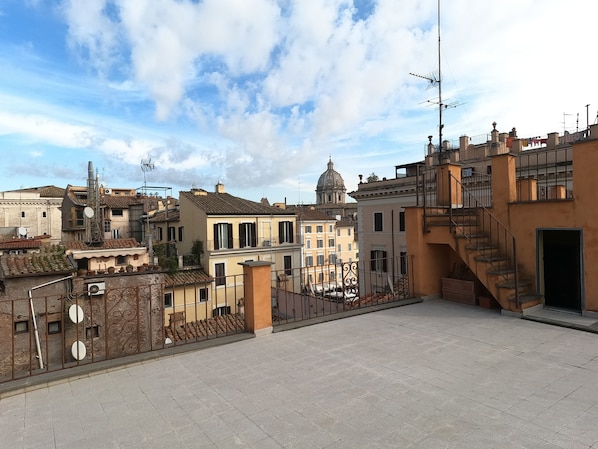A rooftop terrace with a view of historic buildings and a dome structure in the background. - New and elegant apartment in the center of Rome (Roma)