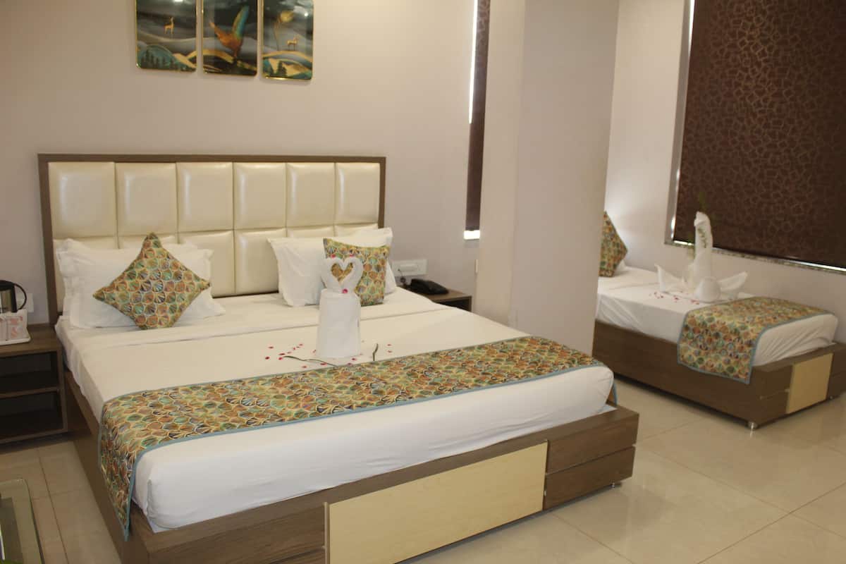 Quarto de hotel com duas camas, uma mesa de cabeceira e um espelho.