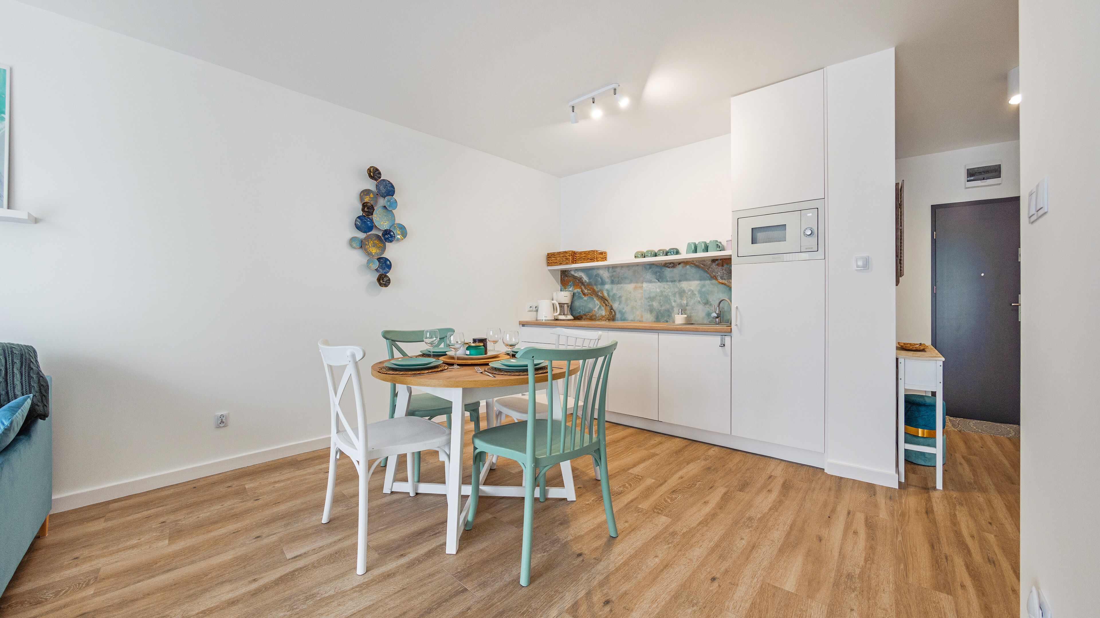 A compact kitchen with white cabinets, a wooden countertop, and a built-in microwave.