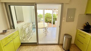 A kitchen with a sliding glass door leading to an outdoor patio area.