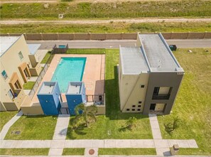 Un bâtiment moderne doté d’une piscine, d’un parking et d’une cour verdoyante.