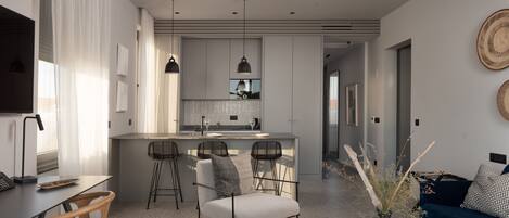 A modern living room with a sofa, a coffee table, and a dining area with a bar.