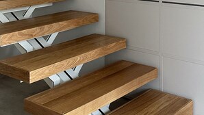A staircase with wooden steps and a white wall.