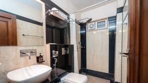 Une salle de bain moderne avec un grand lavabo blanc, des toilettes et un espace douche.