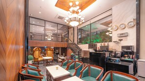 Un hall d’hôtel avec un escalier, un espace salon et une cuisine.
