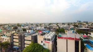 Une vue urbaine avec différents bâtiments, dont un avec une grande enseigne indiquant « ECOSTAY PLAY SALES » et un autre avec l’inscription « Chang’s ».