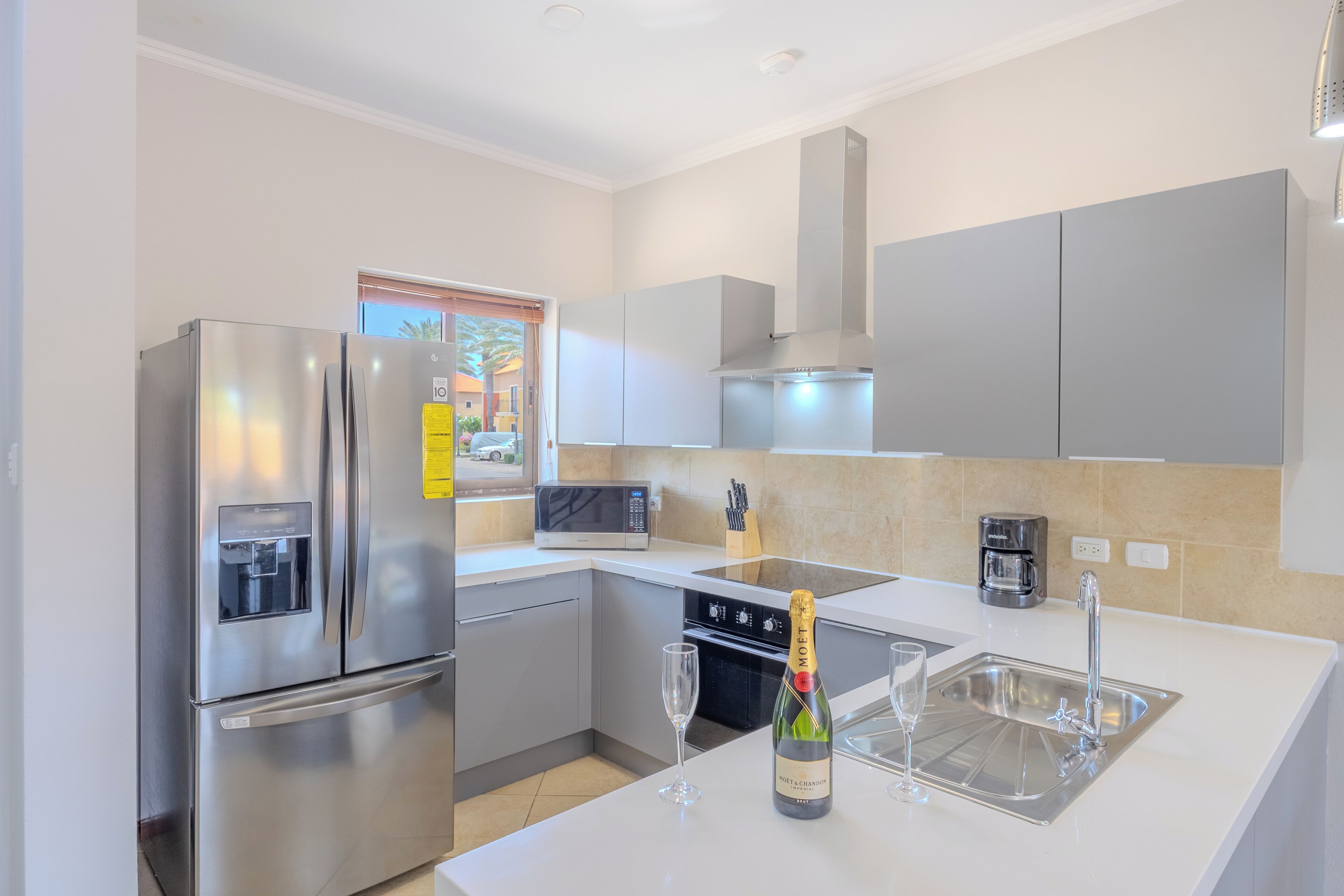 A modern kitchen with stainless steel appliances, a built-in microwave, and a wine glass.