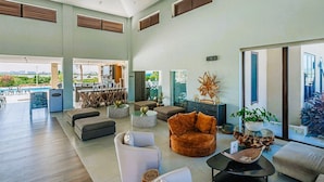 Un vaste espace de vie avec vue sur la piscine, un mobilier moderne et un coin bar.