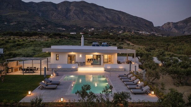 Uma casa moderna com piscina, área de estar externa e vista para montanhas.