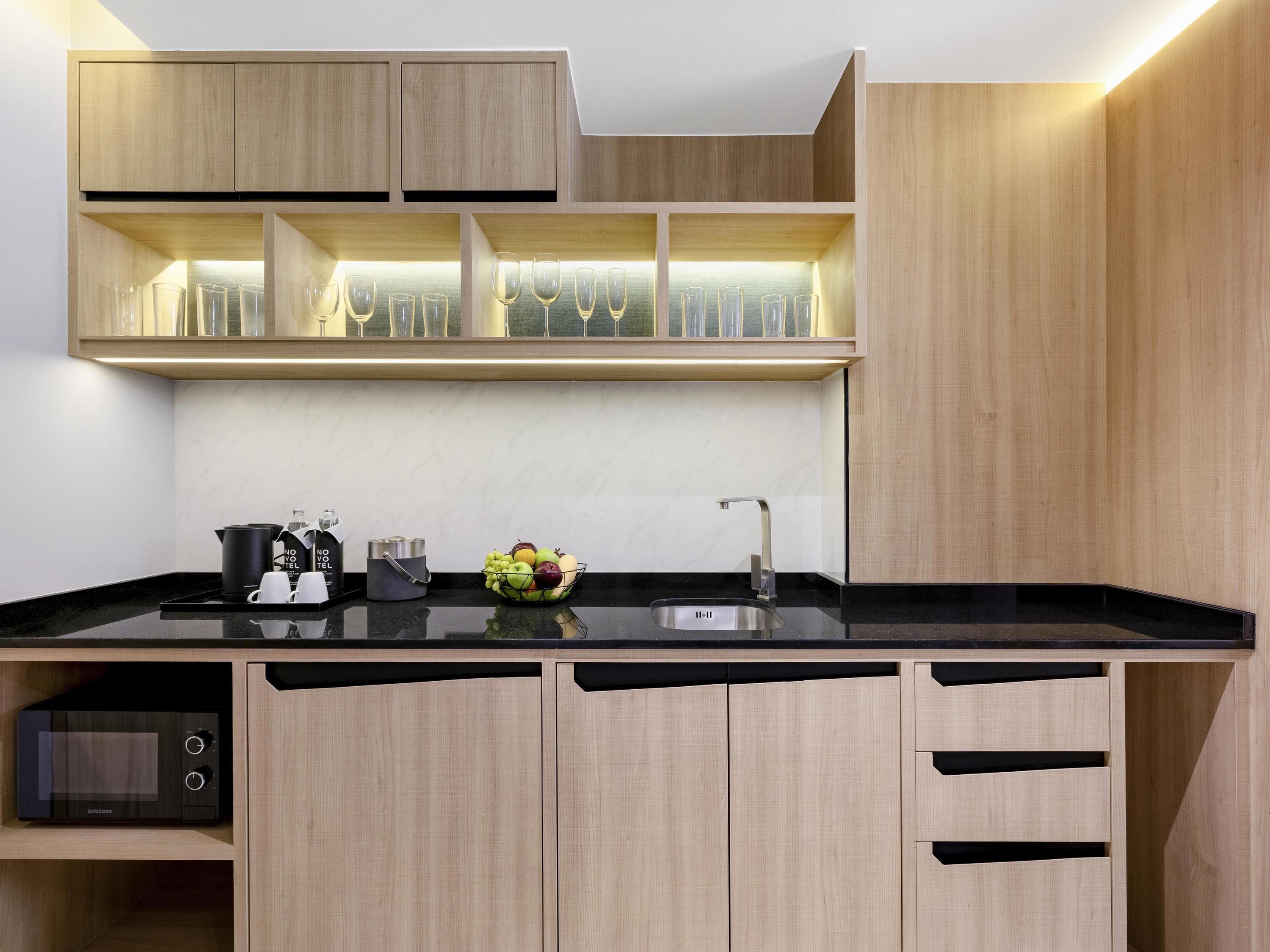 A modern kitchen with wooden cabinets, a black countertop, and a built-in wine rack.