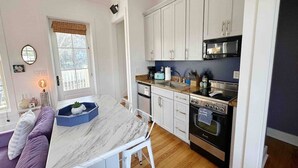 A compact kitchen with white cabinets, a built-in oven, and a microwave. - Scenic Cottage w/ Trails, Pond & Valley Views (Pisgah)