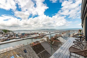 Un balcon donnant sur un port, avec vue sur les bateaux et les bâtiments.