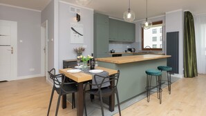 Una cocina moderna con una isla central, taburetes de bar e iluminación colgante.