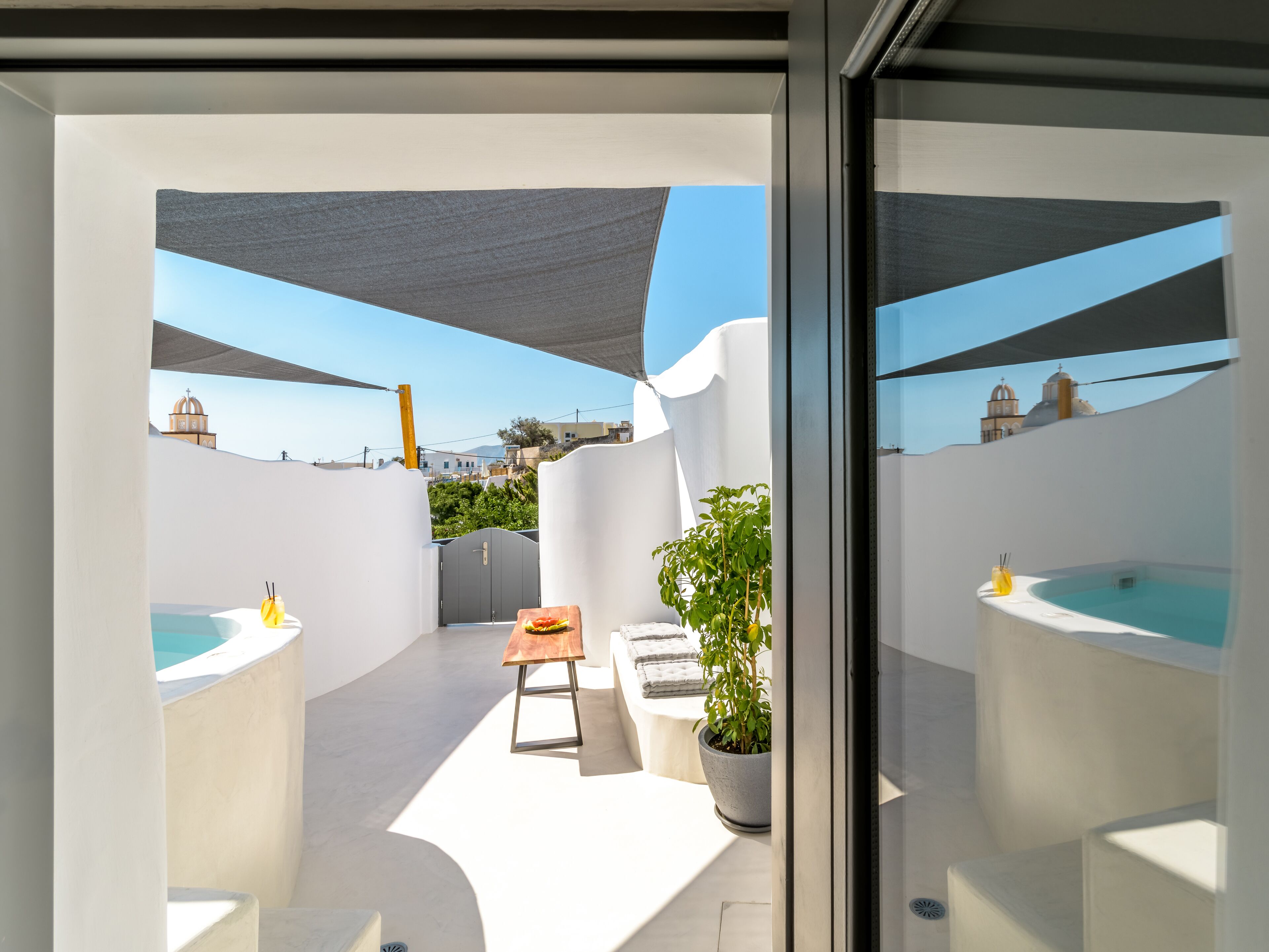 Un espacio exterior moderno con piscina, zona de estar y vistas a la ciudad.