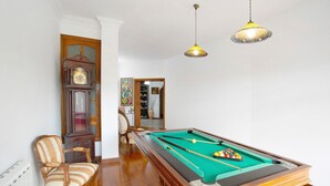 A billiards table with balls, a chair, a clock, and two hanging lamps in a room with wooden flooring and white walls. - Holiday Apartment "Carmelo Y Carmela 6" with Mountain View, Private Terrace & Wi-Fi (Teror)