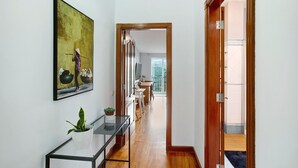 A hallway with a wooden floor, a glass table with a plant, and a painting on the wall. - Holiday Apartment "Carmelo Y Carmela 4" with Mountain View, Private Terrace & Wi-Fi (teror)