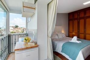 Une chambre à coucher avec un lit, une table de chevet avec une lampe, une fenêtre donnant sur un beau paysage et une armoire.