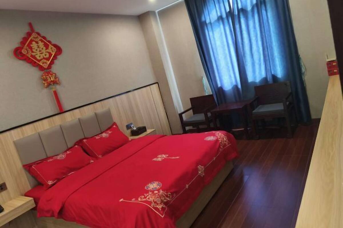 A hotel room with a bed, a desk, and a chair.