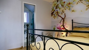 A bedroom with a bed, a decorative wall mural, and a door leading to another room. - Chalet de Paris (Fontenay-sous-Bois)