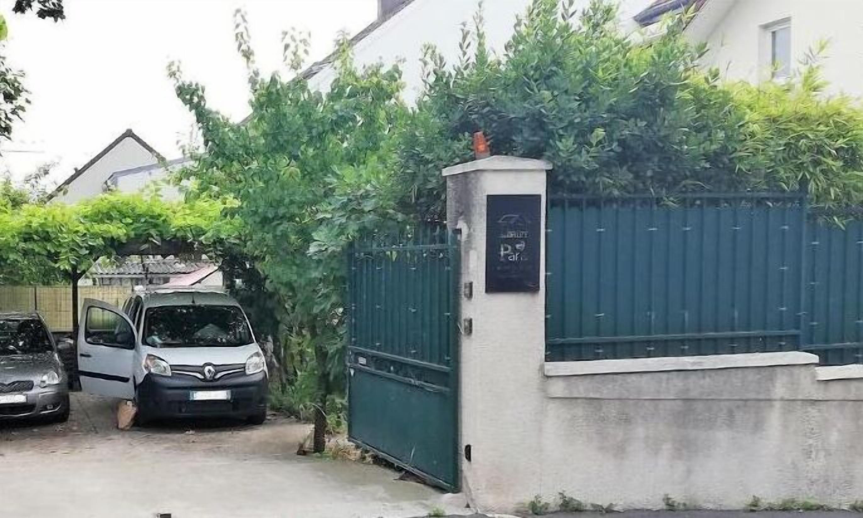 Zona residencial cerrada con coches aparcados y un edificio con un cartel que dice "Park".