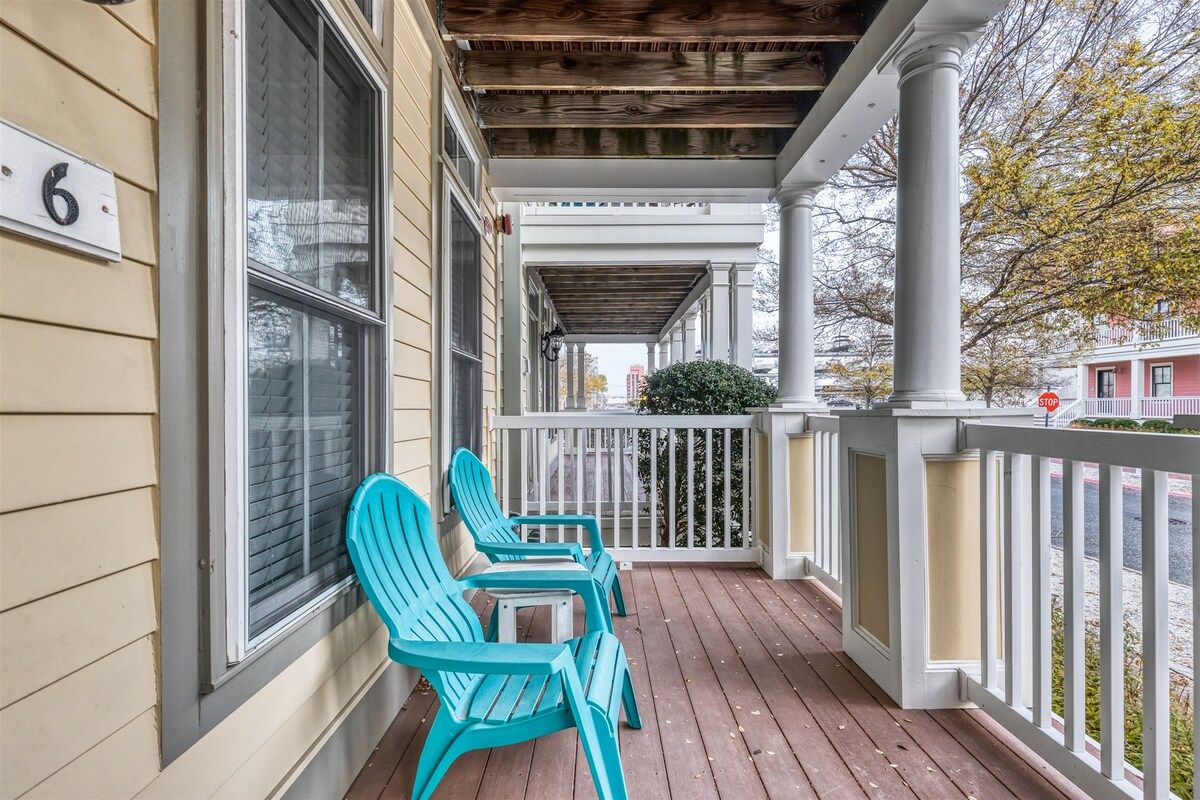 A porch with two chairs and a table, a white railing, and a house number '6'.