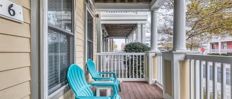 A porch with two chairs and a table, a white railing, and a house number '6'.