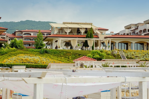 A hotel with multiple balconies, outdoor seating areas, and a landscaped garden. - Mia Casa (Sveti Vlas)
