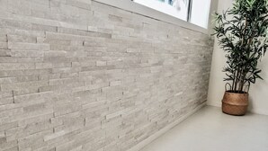 A modern interior with a textured brick wall and a potted plant.