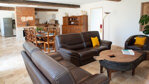 Un vaste espace de vie comprenant un canapé en cuir, une table basse en bois et un ensemble de salle à manger.